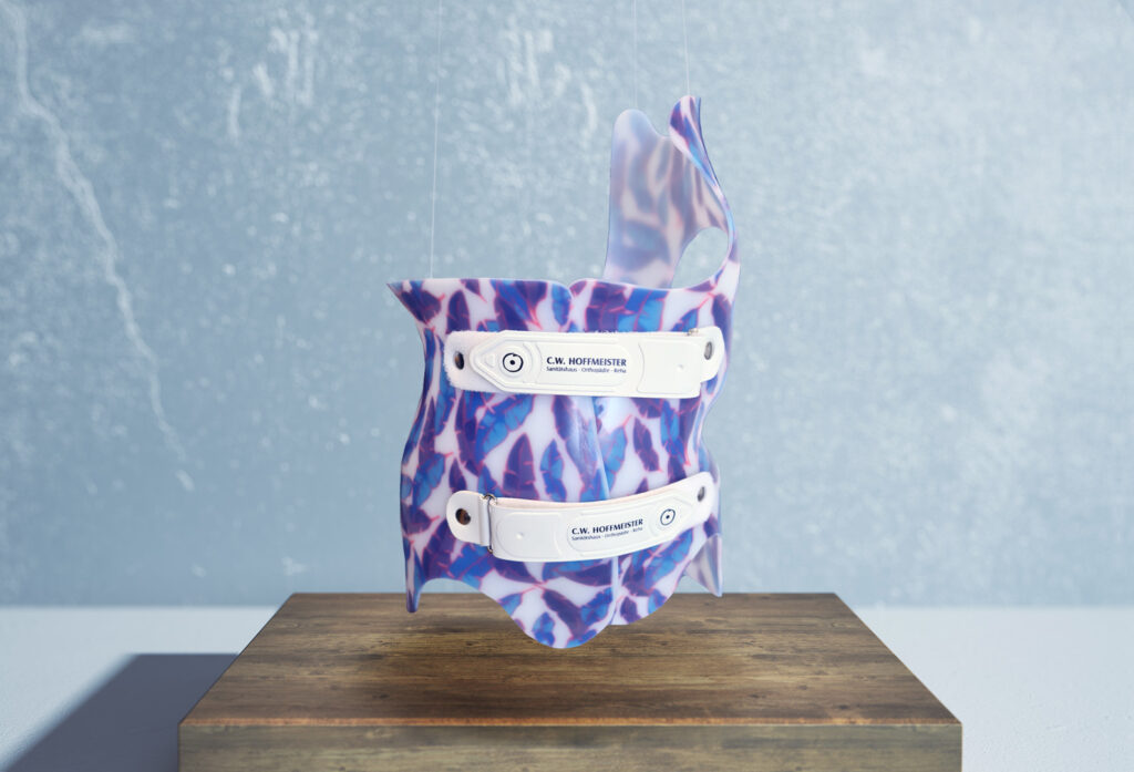 Korsett mit blauen und violetten Federn von C.W. Hoffmeister