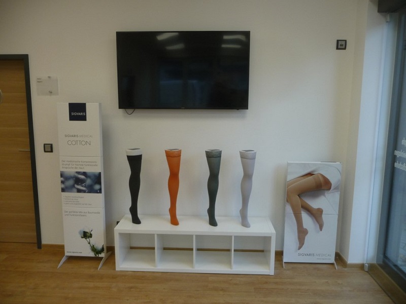 Vierbaum Filiale Hennef vier Kompressionsstrümpfe und TV an der Wand