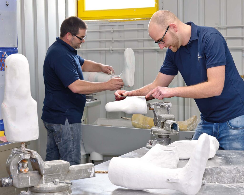 Gipsabdrücke werden von Orthopädietechnikermeister bearbeitet um Prothesen herzustellen
