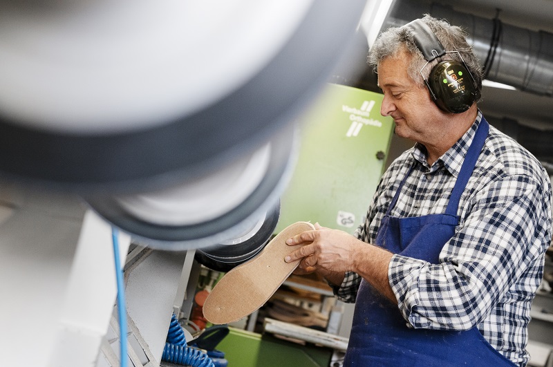 älterer Orthopädietechniker schleift die Einlagen Vierbaum Wiehl
