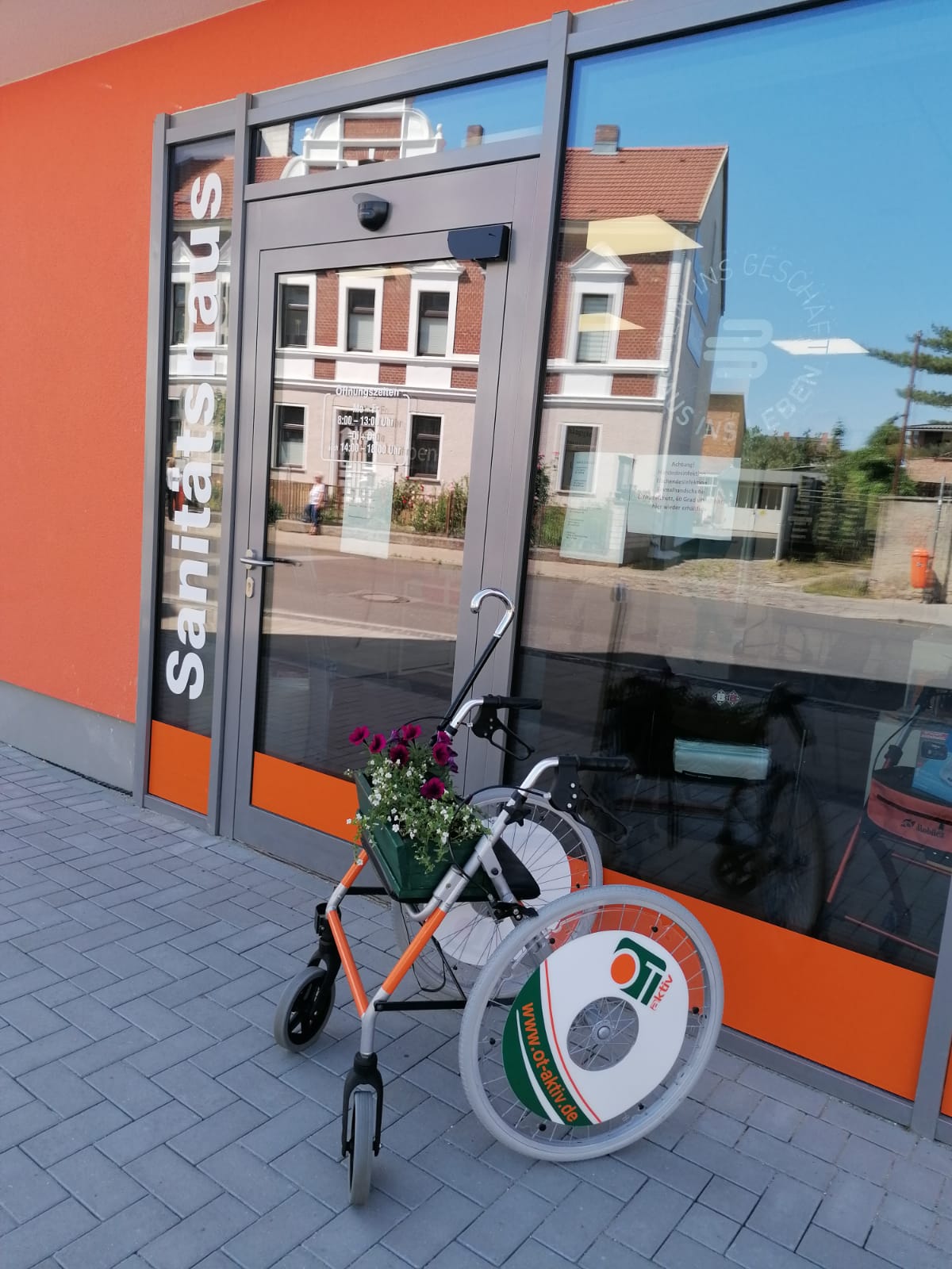 OT-aktiv Filiale in Demmin Außenansicht mit Rollator und Blumen