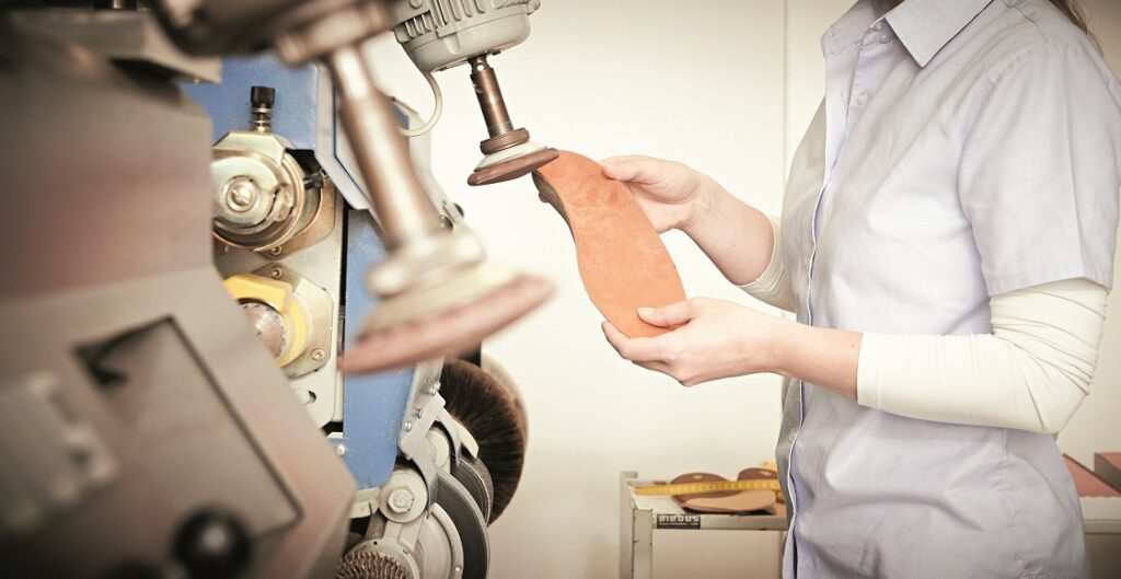 orthopädische Einlage wird von einer Dame in der OT-aktiv Filiale geschliffen