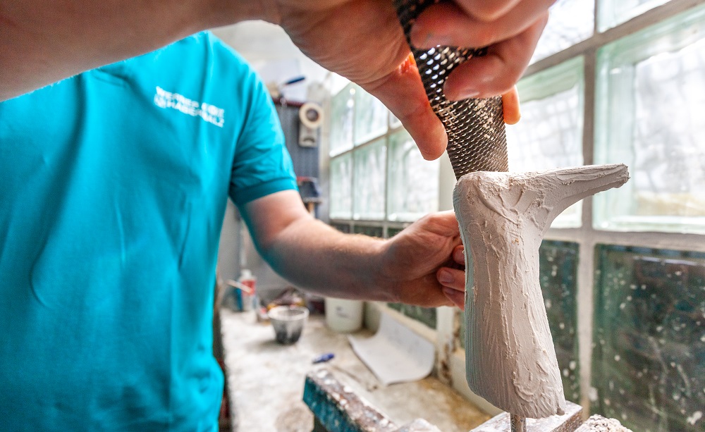 Mitarbeiter schleift an Modellfuß