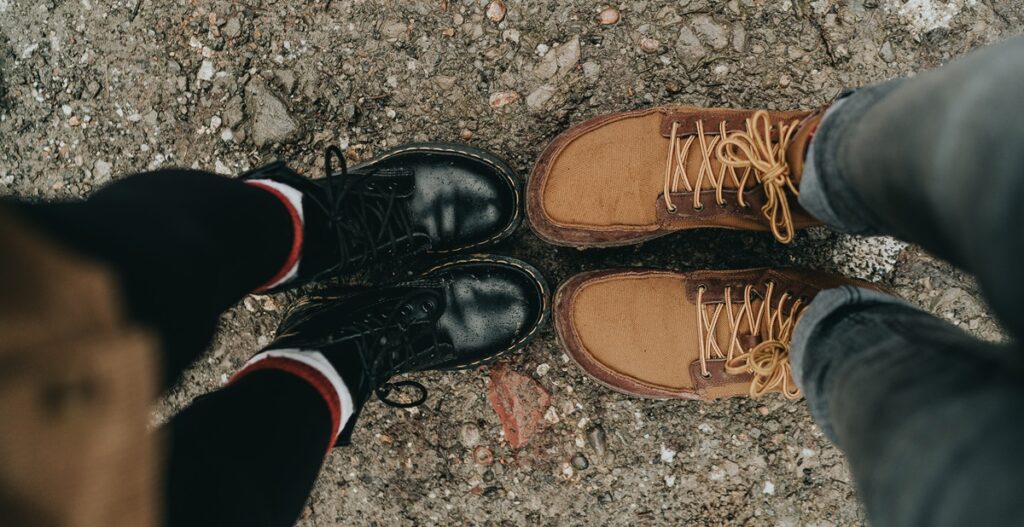 Schwarze und braune massive Stiefel von oben fotografiert.